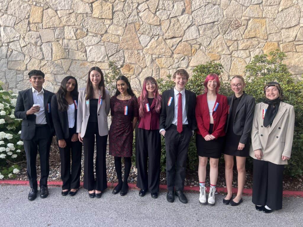 Students in formal attire celebrating at Albuquerque Academy graduation event.
