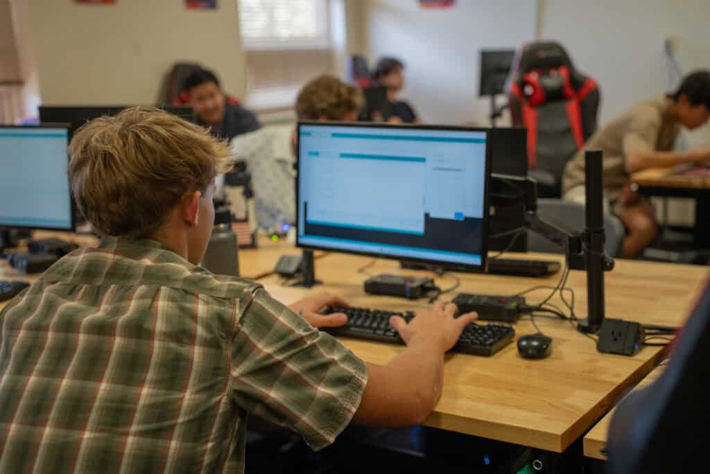 Student working on computer in classroom at Albuquerque Academy, technology education, student engagement.