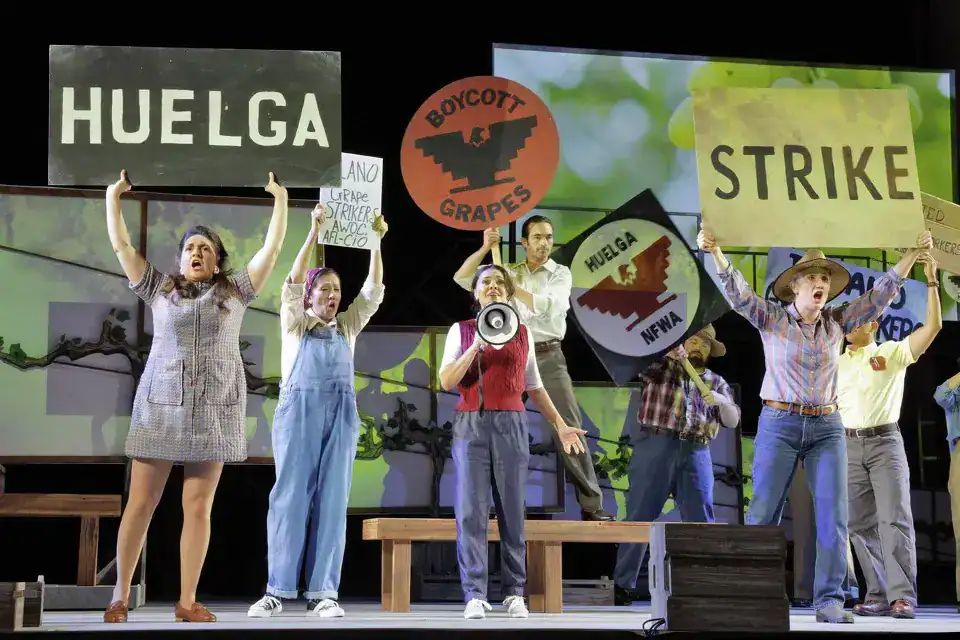 Huelga protest signs at a theatrical performance, highlighting activism and student involvement.