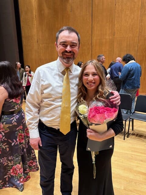 Albuquerque Academy student receiving award with teacher at school event.