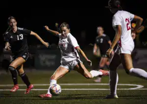 Albuquerque Academy girls soccer players competing during night game.
