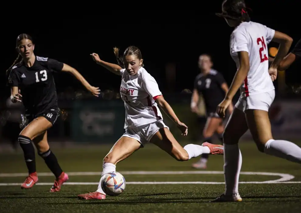 Albuquerque Academy girls soccer players competing during night game.