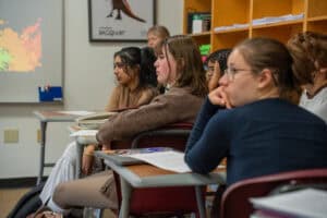 Students attentively listening in an Albuquerque Academy classroom, engaging in a high school lesson aimed at academic excellence.