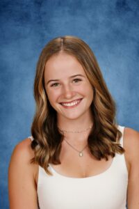 Albuquerque Academy student smiling, portrait, blue background, high school achievement.