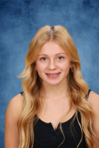Albuquerque Academy student with long blonde hair smiling at school photo.
