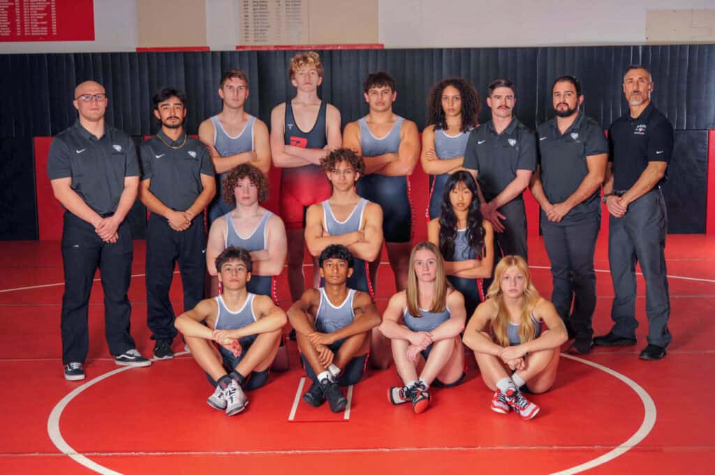 Albuquerque Academy wrestling team at state podium with medals and coaches.