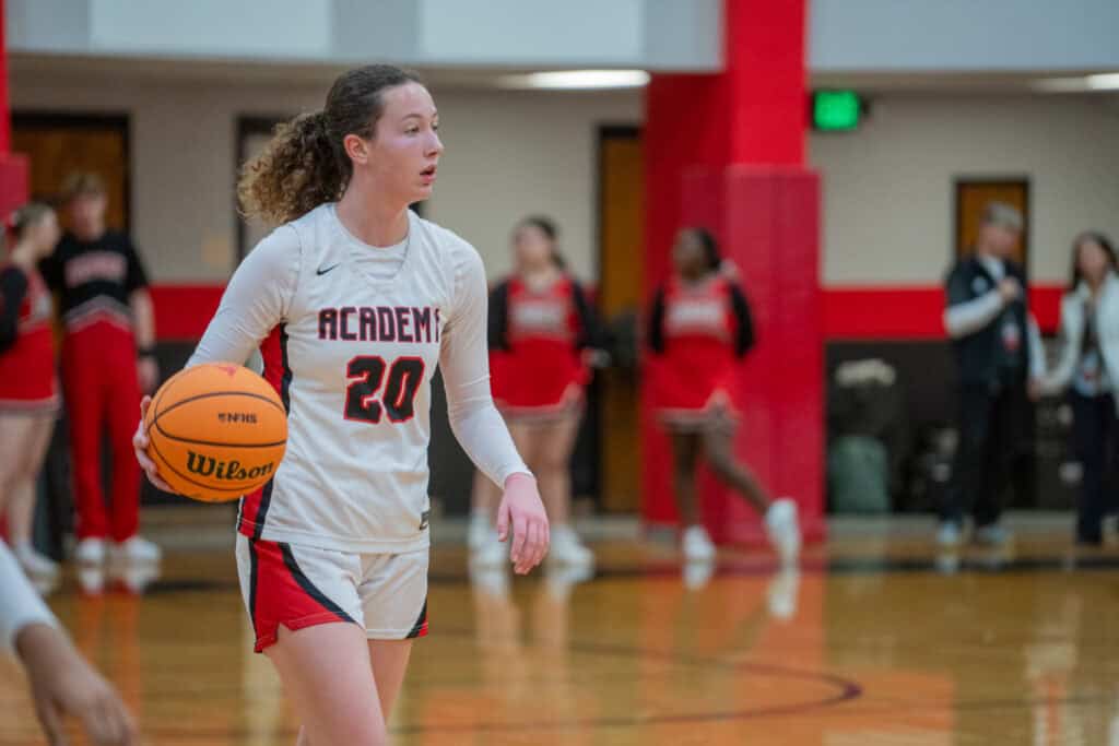 Albuquerque Academy girl basketball player holding a Wilson basketball during a game.