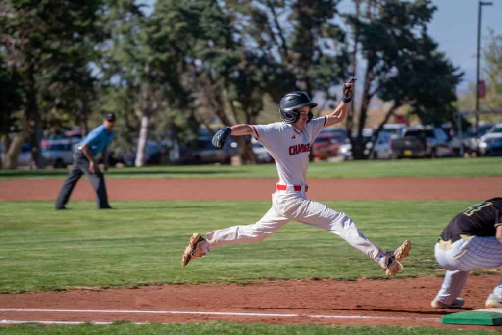 Albuquerque Academy baseball player sliding into base during game.