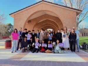 Albuquerque Academy Speech & Debate team with students holding awards outdoors.