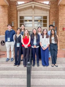 Albuquerque Academy students standing on school steps outside building with brick facade.