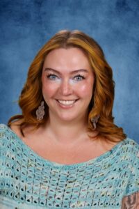 Smiling woman with red hair against blue backdrop
