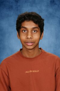 Albuquerque Academy student portrait with blue background and casual clothing.