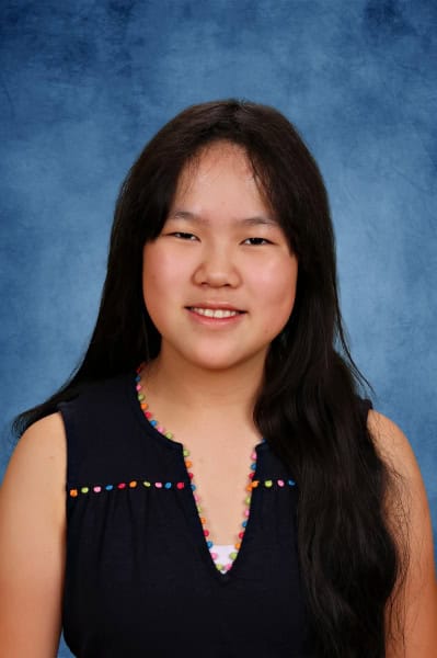 Albuquerque Academy student portrait with blue background, diverse student, education, learning.