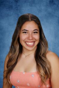 Albuquerque Academy student smiling in school portrait with blue background.