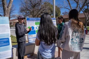 Albuquerque Academy students presenting science project at outdoor STEM event.