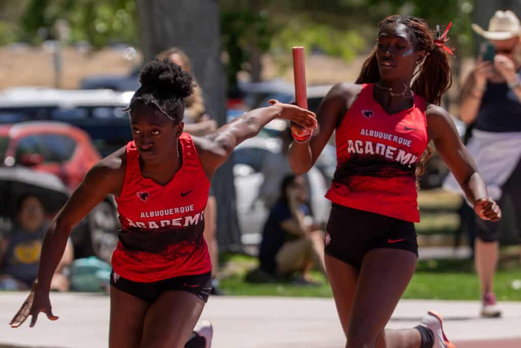 Albuquerque Academy track athletes competing in a relay race at Harper track meet.