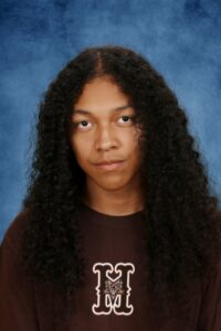 Albuquerque Academy student with curly hair in a portrait photo.