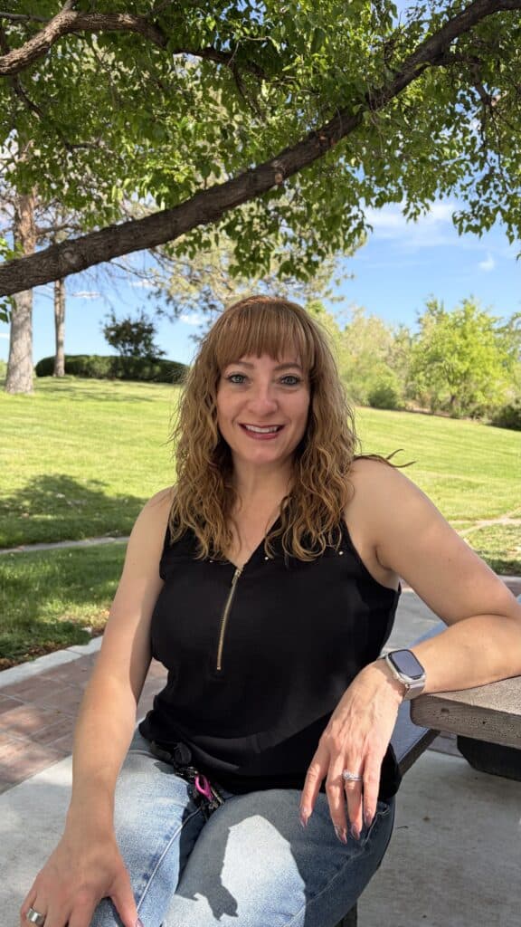 Woman smiling on park bench under tree