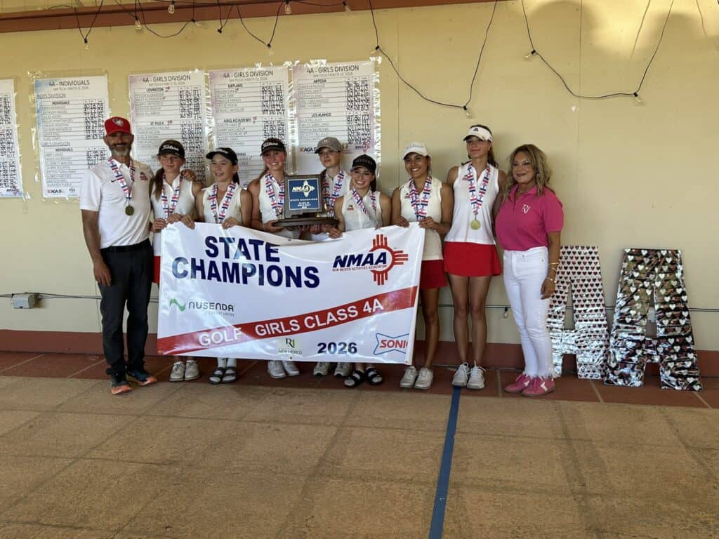 Albuquerque Academy girls golf team celebrating state championship victory with banner and coach.