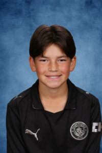 Albuquerque Academy student smiling in sports uniform for school photo.