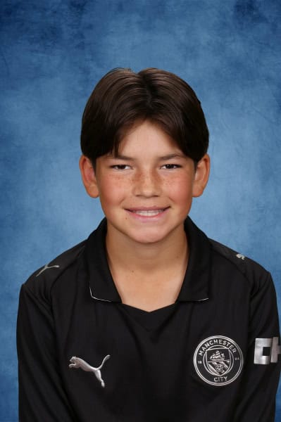 Albuquerque Academy student smiling in sports uniform for school photo.