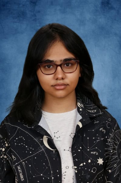 Albuquerque Academy student wearing glasses and celestial-themed jacket for academic excellence.