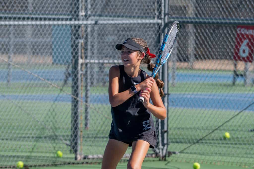 Albuquerque Academy female tennis player preparing to hit a shot on the court.