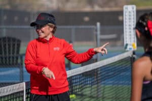 Albuquerque Academy tennis coach Badger giving instructions on the court.