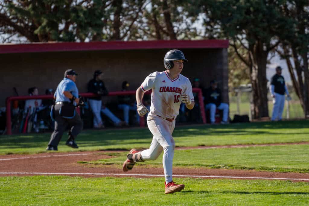 Albuquerque Academy baseball player running on the field during a game.