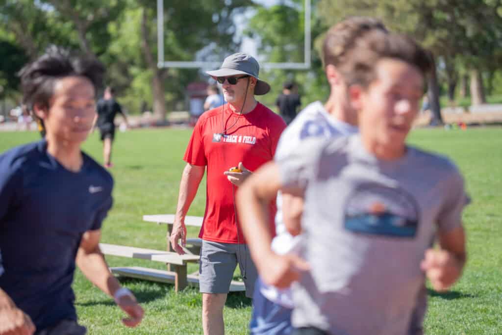 Albuquerque Academy track coach overseeing students during outdoor practice.