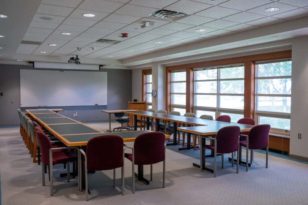 Modern classroom with large windows, tables, and chairs at Albuquerque Academy.