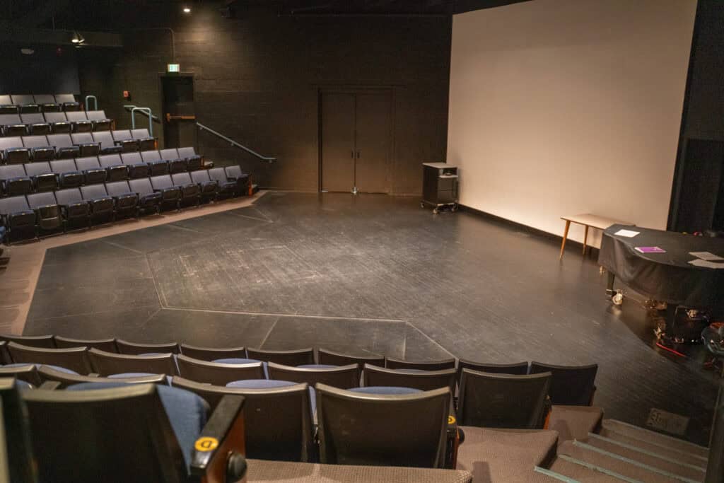 Empty theater stage at Albuquerque Academy with seating and stage setup.