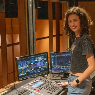 Lillian DSC09275 Young girl working at a music production studio with multiple monitors and audio equipment.