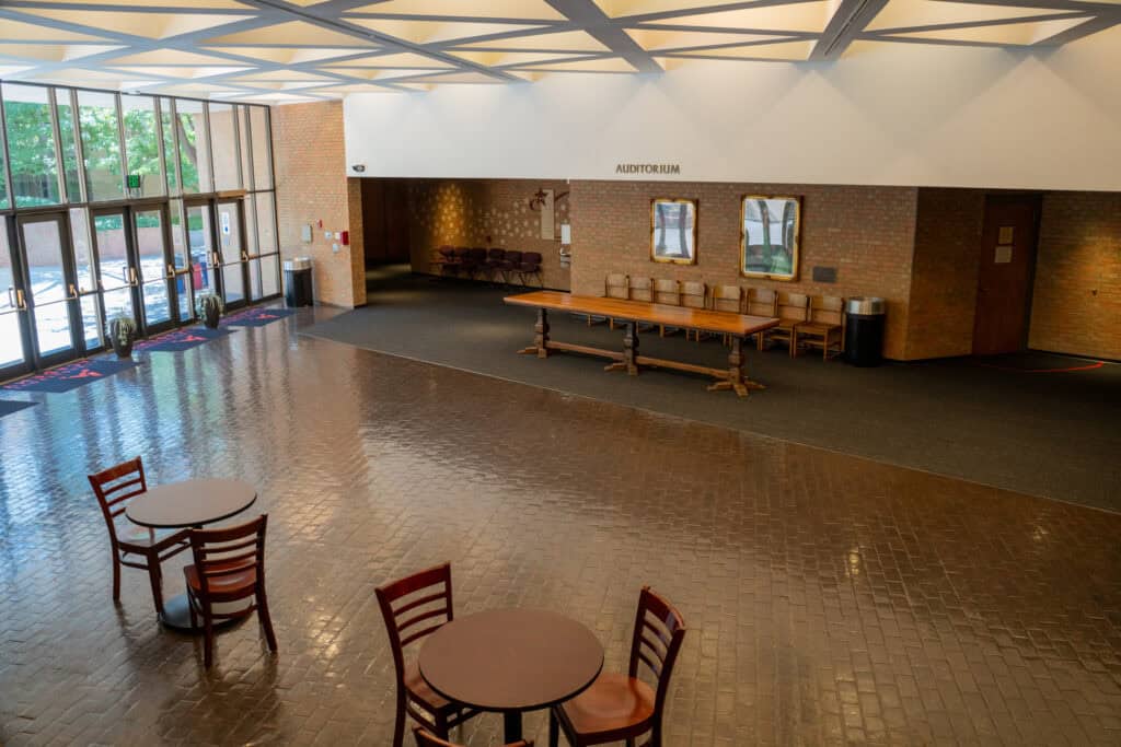 Interior view of Albuquerque Academy auditorium lobby with seating area and entrance.