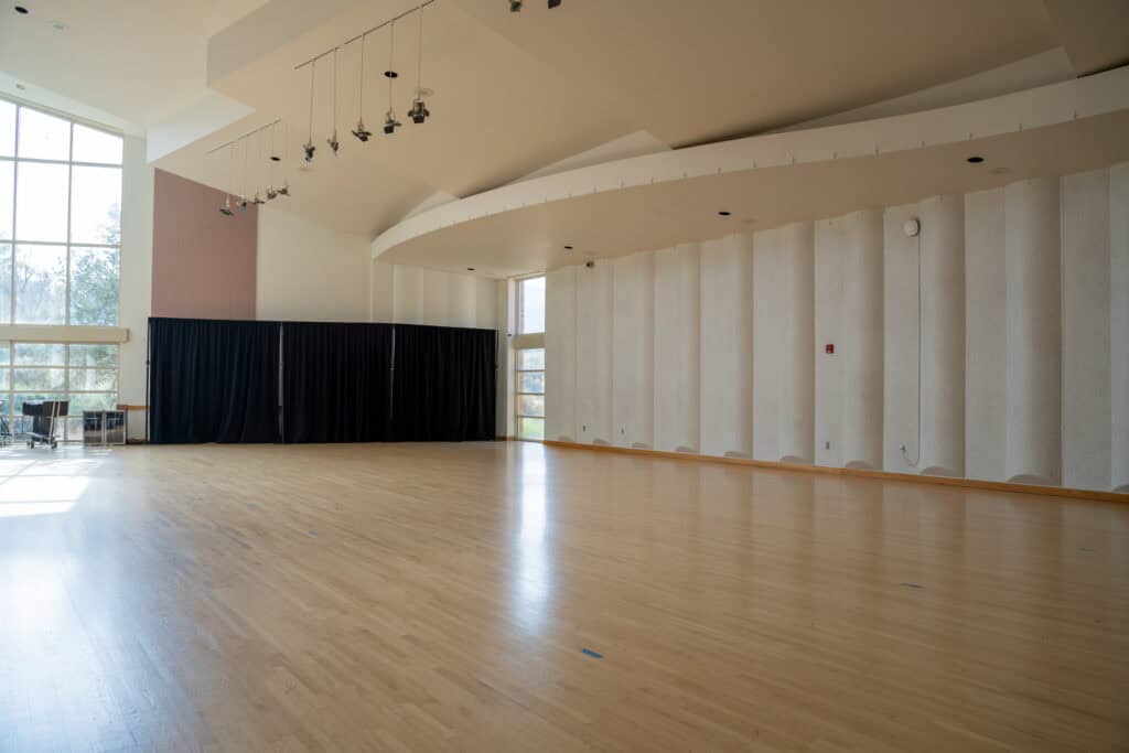 Spacious, empty auditorium with wooden floor and large windows at Albuquerque Academy.