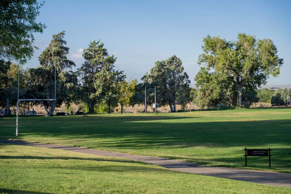 Albuquerque Academy campus with green fields and trees under a blue sky.
