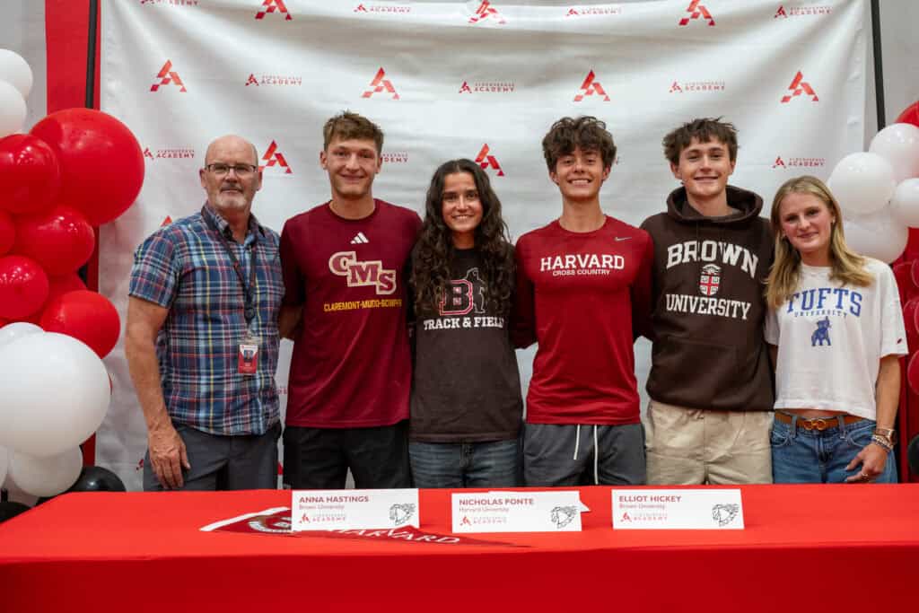 Group of students and coach at Albuquerque Academy signing event with Harvard and Brown University.
