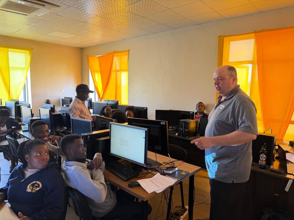 Albuquerque Academy students in a computer lab with teacher and bright yellow curtains.