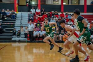 High school basketball players sprinting during a game