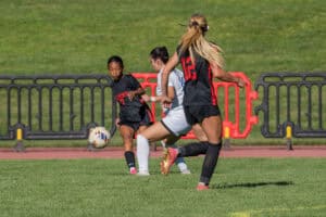 Three youth soccer players compete for the ball.
