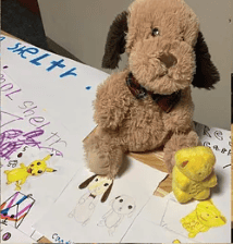 Stuffed dog and yellow toys on children's drawings